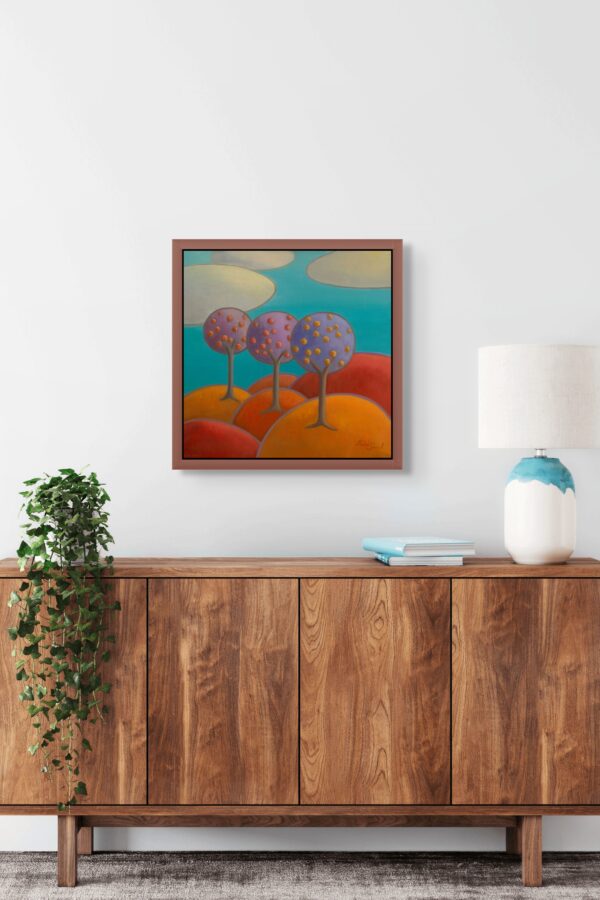 Framed naïve-style painting of three colorful trees resembling a small grove, inspired by childhood stories, displayed in a cozy modern interior
