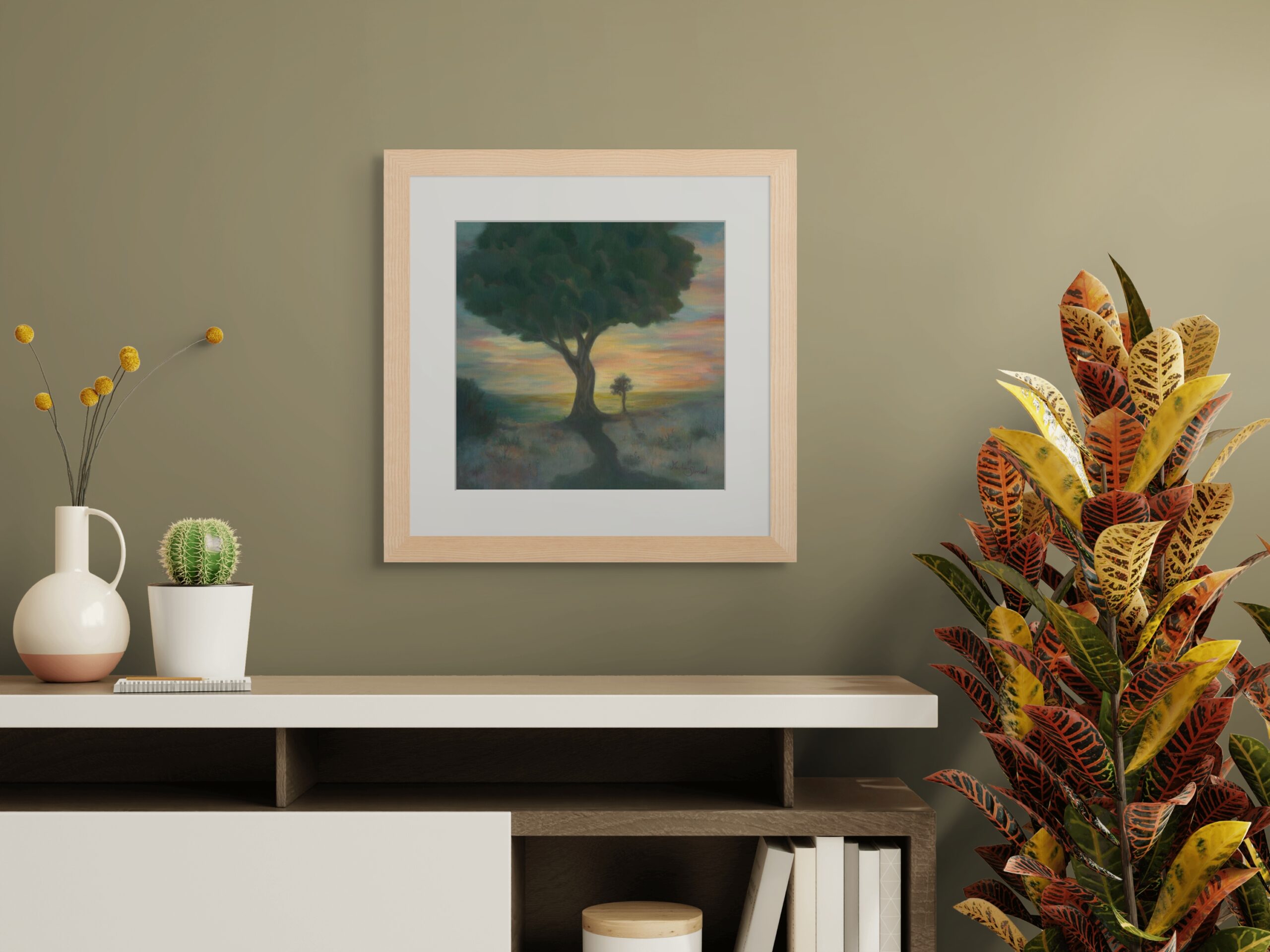 Framed painting of a large tree at sunset with warm glowing light, creating a serene and reflective atmosphere in a modern interior.